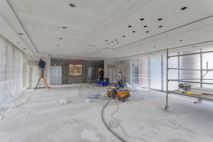 Peintre en batiment qui utilise une toile de protection